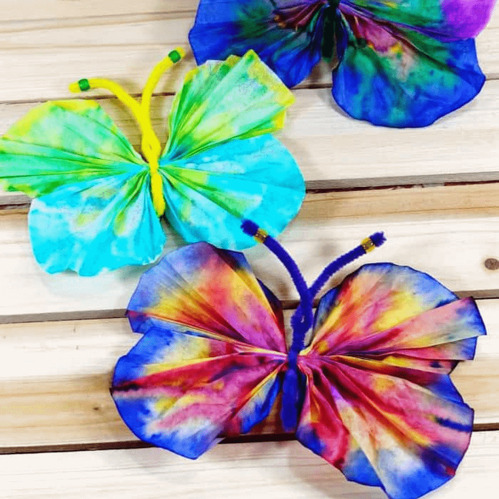 Photograph of tie-dyed butterflies made from coffee filters, markers, water, pipe cleaners, and pony beads.
